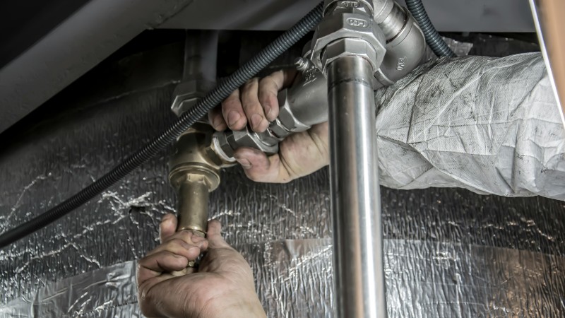 Close-up of a plumber's hands installing steel pipes indoors, showcasing skilled manual work., tags: hamburger - pexel